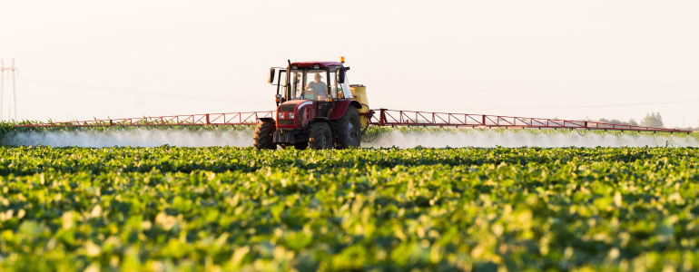 Farm tractor fertilizing crop